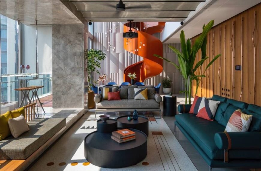 An Orange Spiral Staircase Is An Eye-Catching Feature Inside This Apartment