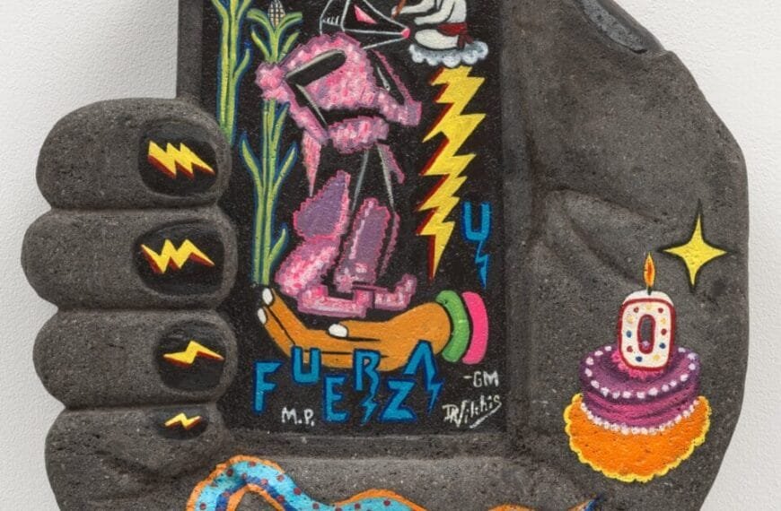 a concrete hand sculpture holding a rectangular form with a birthday cake and o candle, blue snack, symbols, rabbit, and corn painted on it. lightning bolts are painted on the fingernails