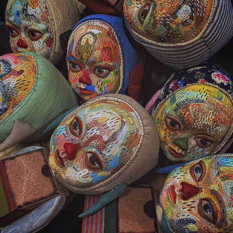 a collection of wooden dolls with patterned paintings on their faces