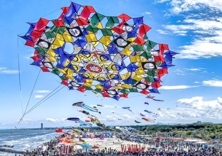 This April, Thousands of Kites will Paint the Sky for an International Festival of Flight 57 a massive vibrant kite in the sky above a beach