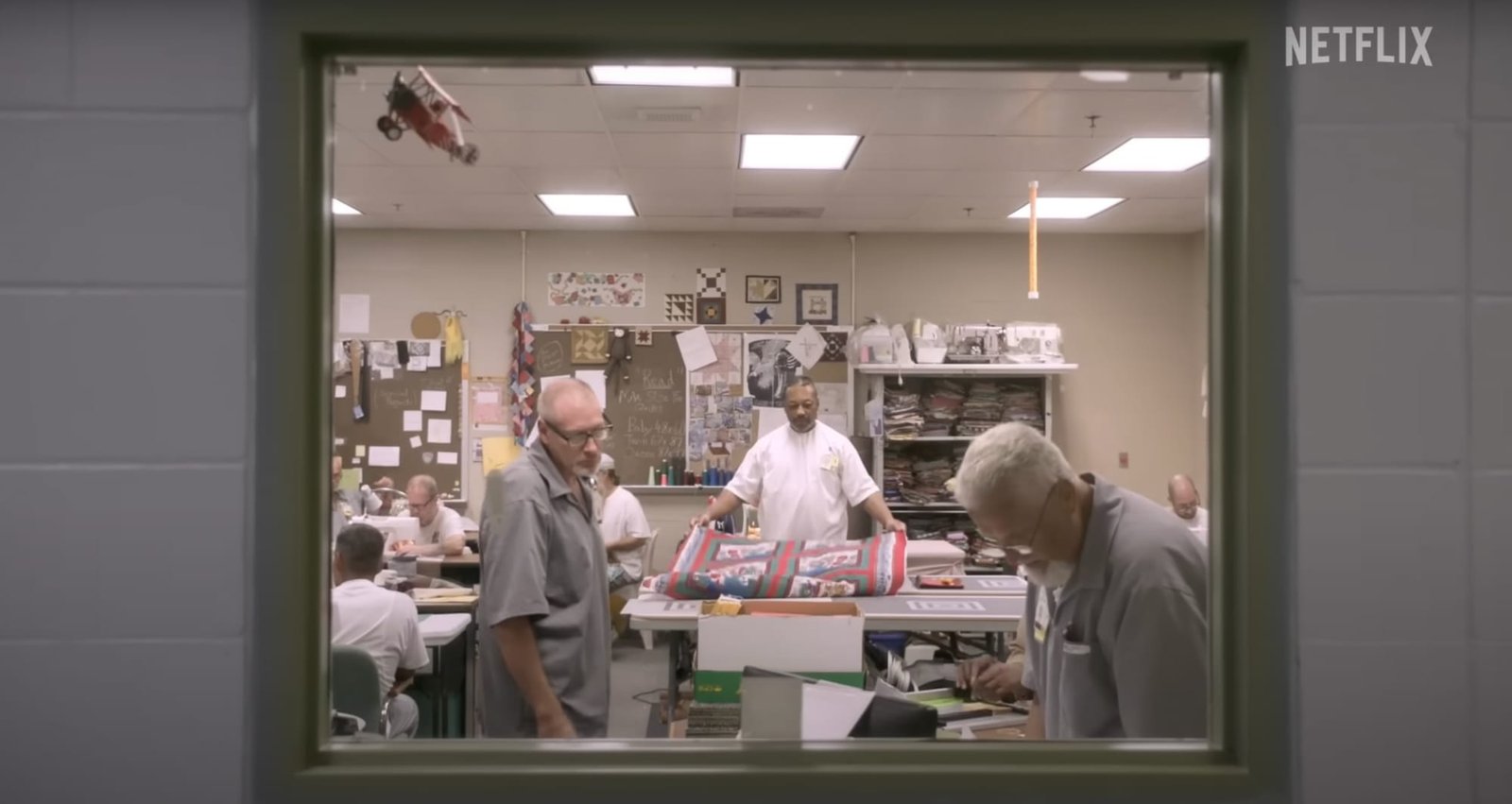 a still of the sewing room with men working