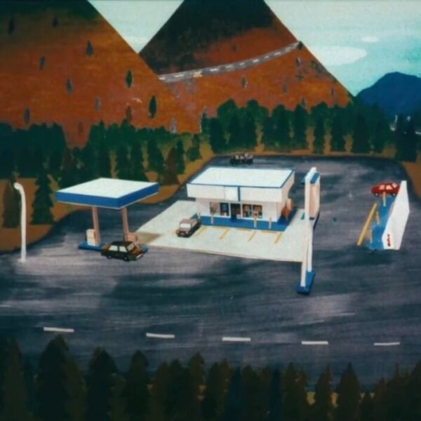 a still from a stop-motion animated video of a gas station and some mountains