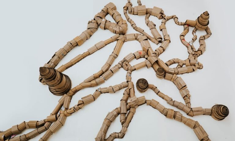 Sprawling sculpture made of cardboard roles meant to look like wood or ant hills and the tunnels that connect them.