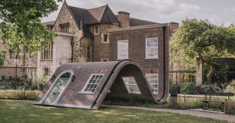 alex chinneck’s brick facade sculpture sits down in london
