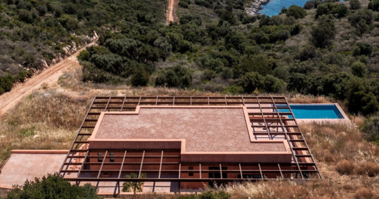 ateno's clay house overlooks mountains and sea on greek island