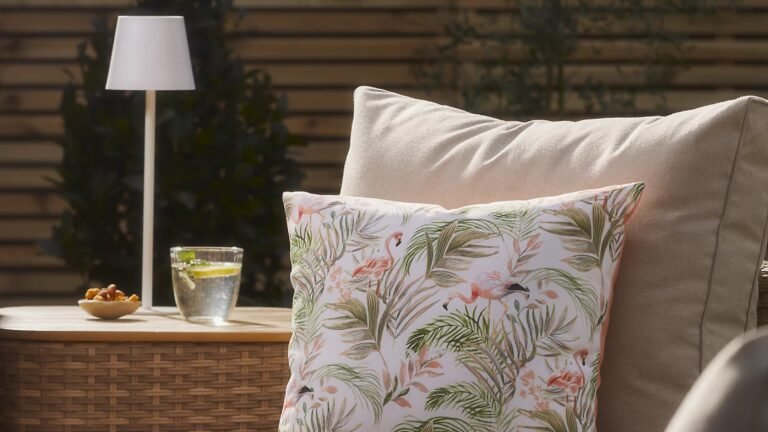 GoodHome Quelea Integrated LED Table lamp in white on a side table in the garden