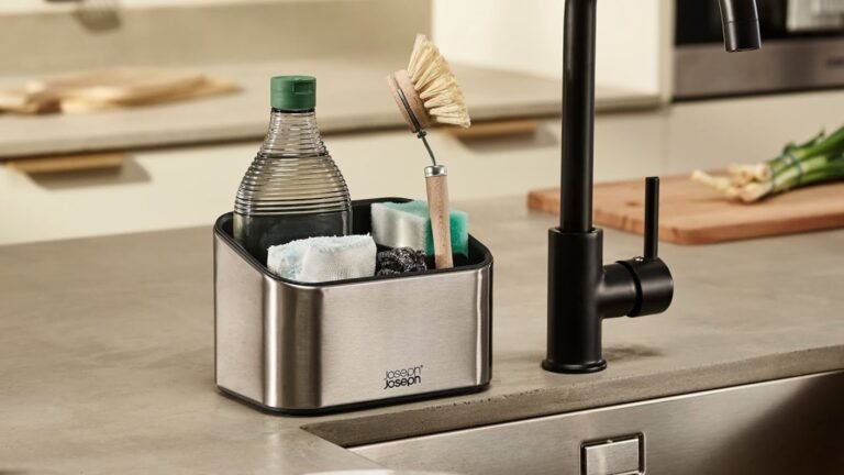 Silver Joseph Joseph sink caddy full of cleaning products next to a sink