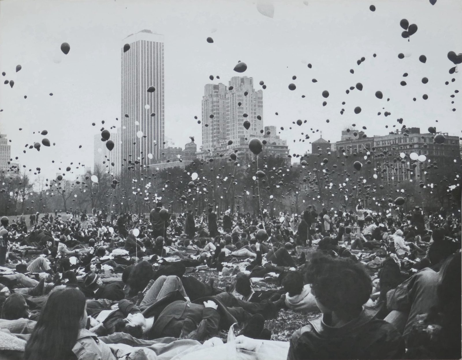 صورة بالأبيض والأسود للبالونات التي يتم إطلاقها على حشد من الناس على الأرض