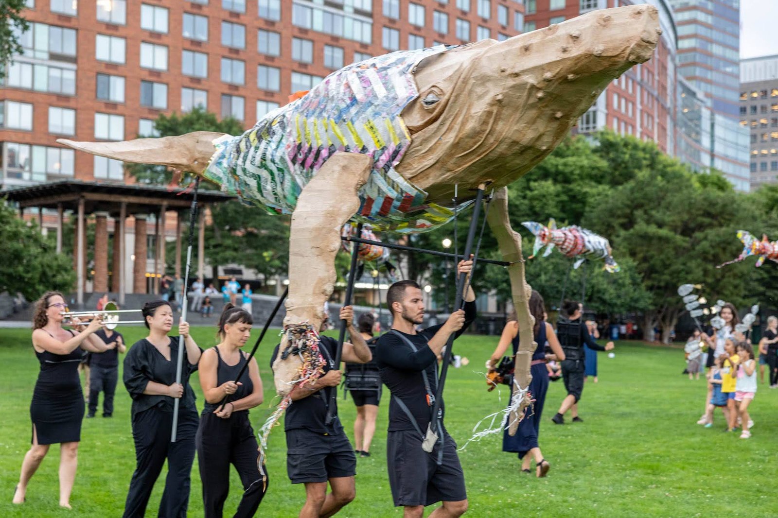 يحمل الناس دمية كبيرة من الحوت على عمود