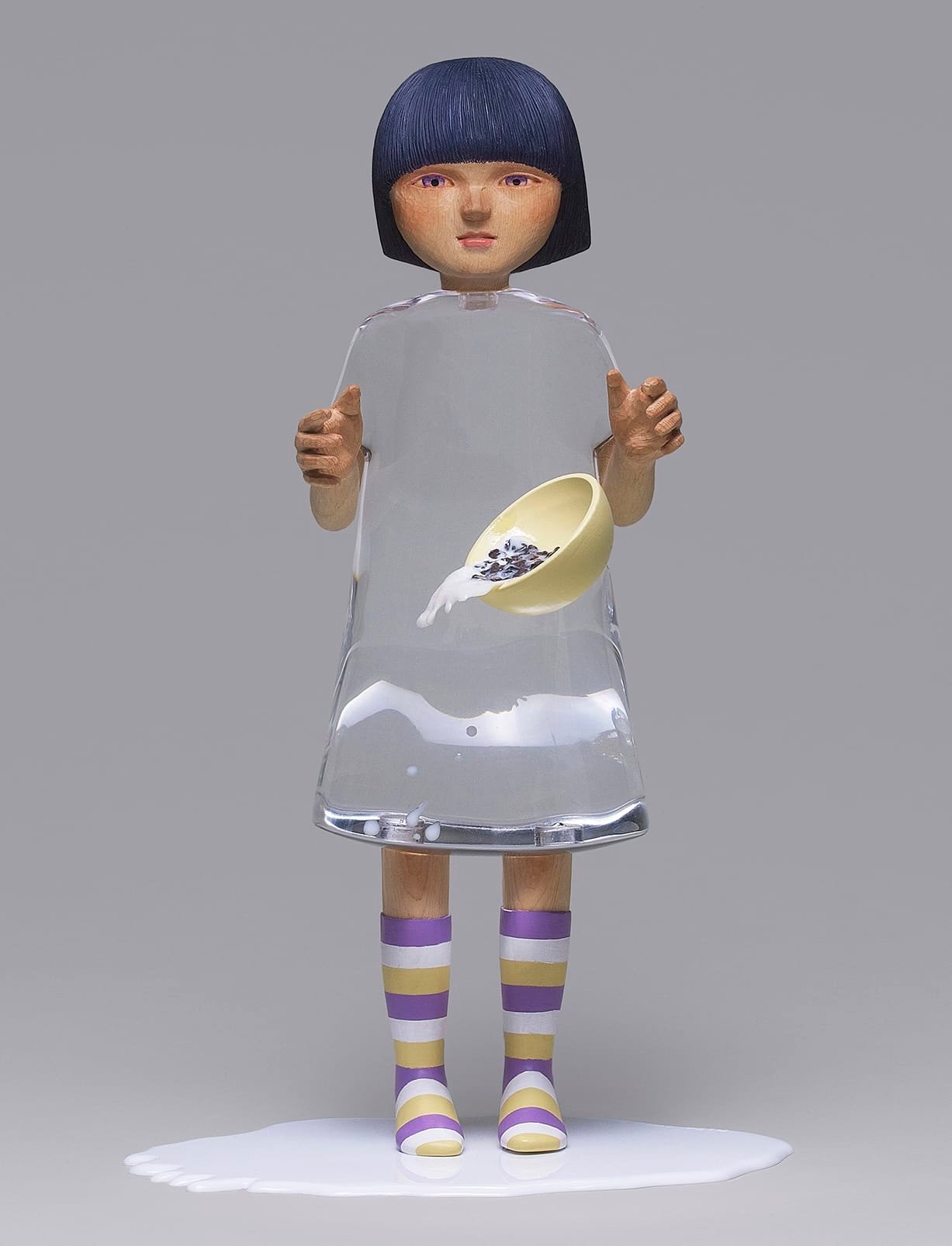 two views of a sculpture by Ayako Kita of a young woman with a carved wood head and clear resin dress