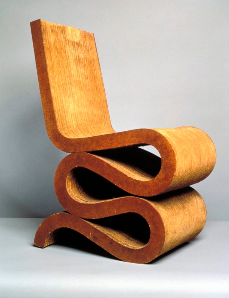 An iconic chair designed by Frank Gehry made from corrugated cardboard that has a straight back and a wiggle shape at the base