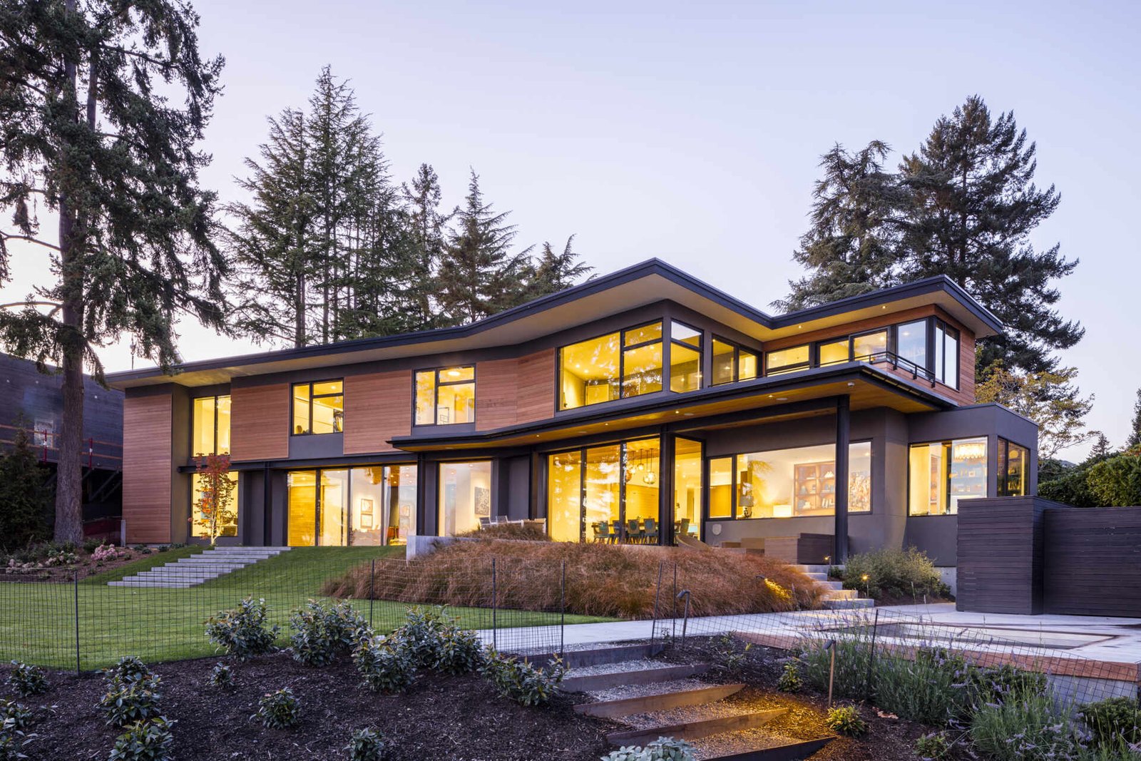 A Boomerang-Shaped Home with an Art Studio and Lake Views 1 A boomerang-shaped lakefront home curves into the hillside, carefully orienting living spaces toward Mt. Rainier and Lake Washington.