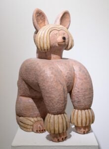 a wood-carved sculpture of a dog by Misato Sano