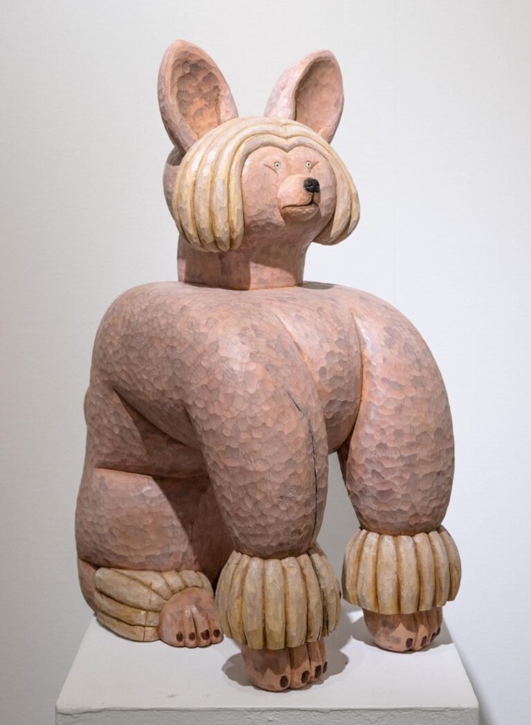 a wood-carved sculpture of a dog by Misato Sano