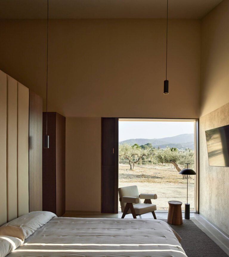 The bedrooms are located in the more private wing of the house. Each one includes its own bathroom and dressing area, giving a sense of independence within the home. In the bathroom, a glass enclosed shower looks out onto the landscape, while hidden lighting creates a dramatic effect.