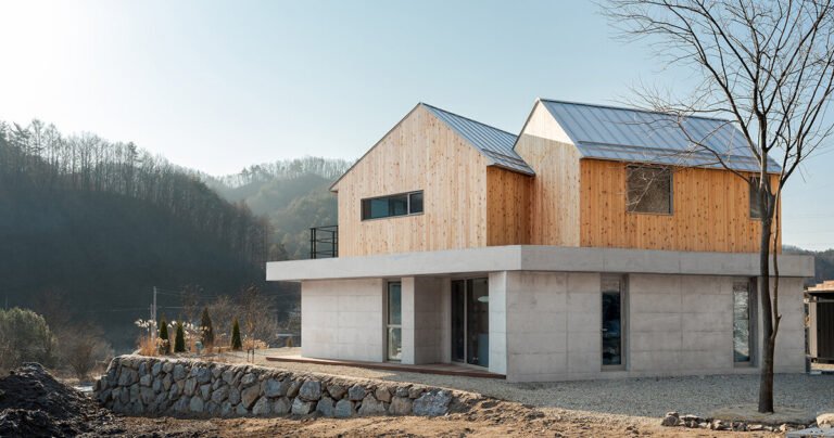 this home in korea is shaped by twin timber gables atop a concrete base