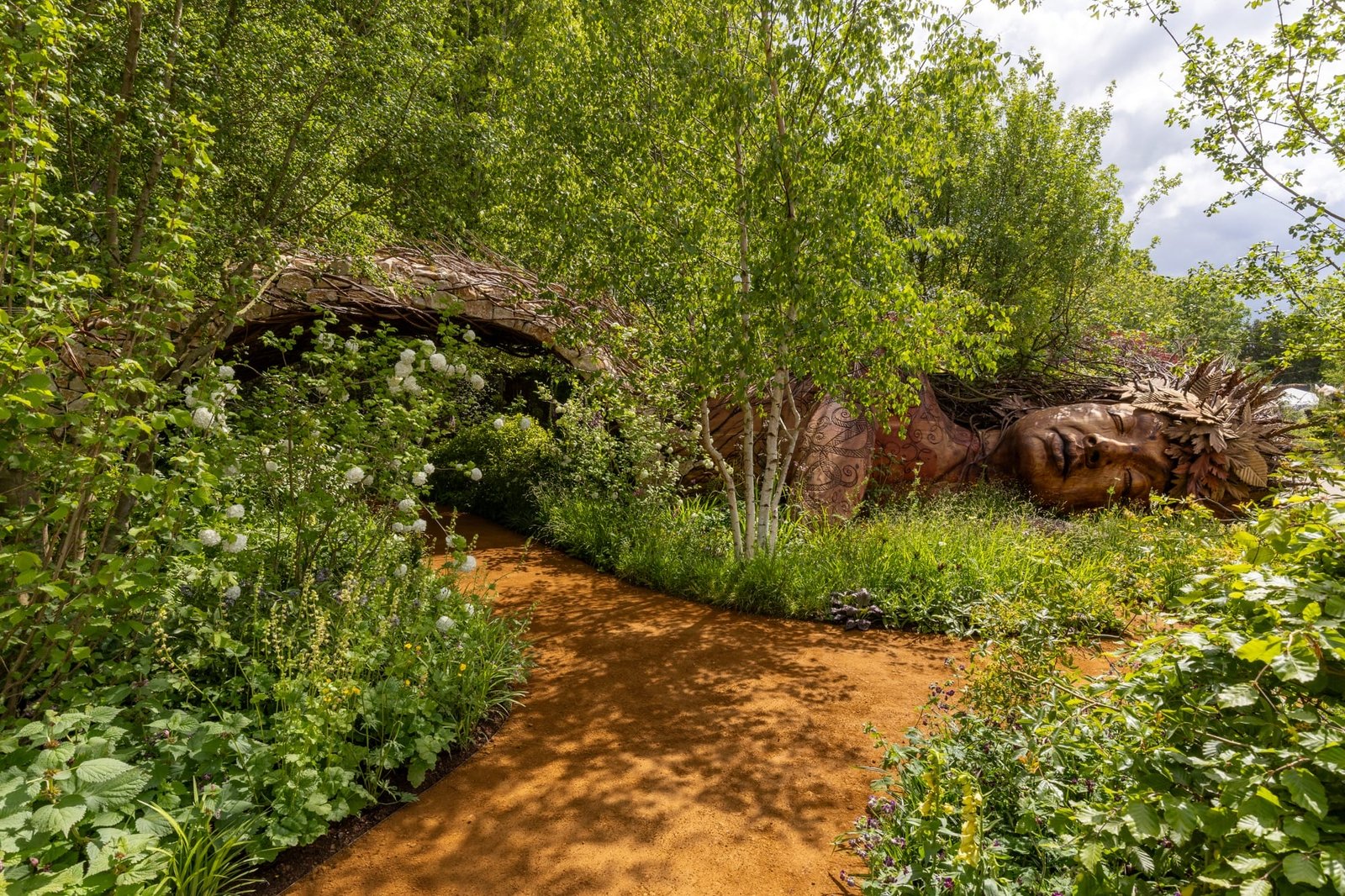 تمثال خشبي لـ Gaia وسط حديقة صممتها سارة إيبرل في RHS Chelsea Flower Show