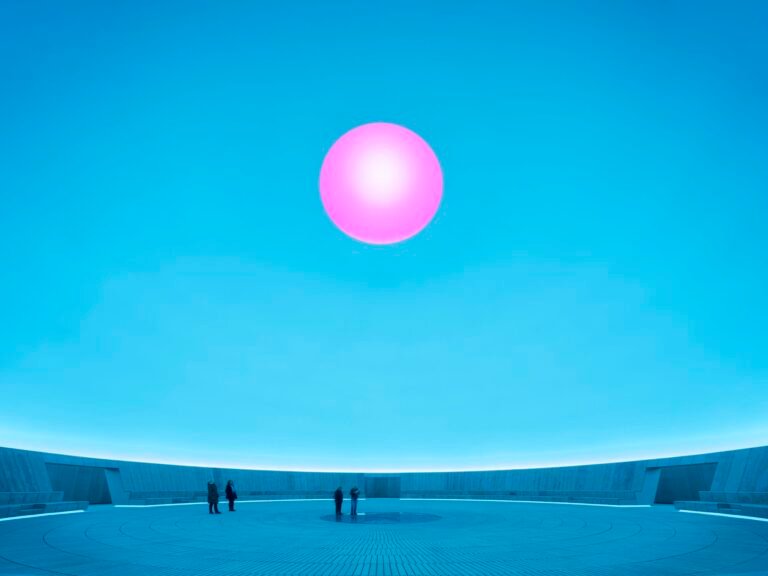 a large-scale light exhibition by James Turrell featuring a pink hole in a blue dome