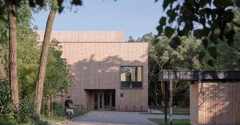 public library clad in washed timber integrates with warsaw's forest