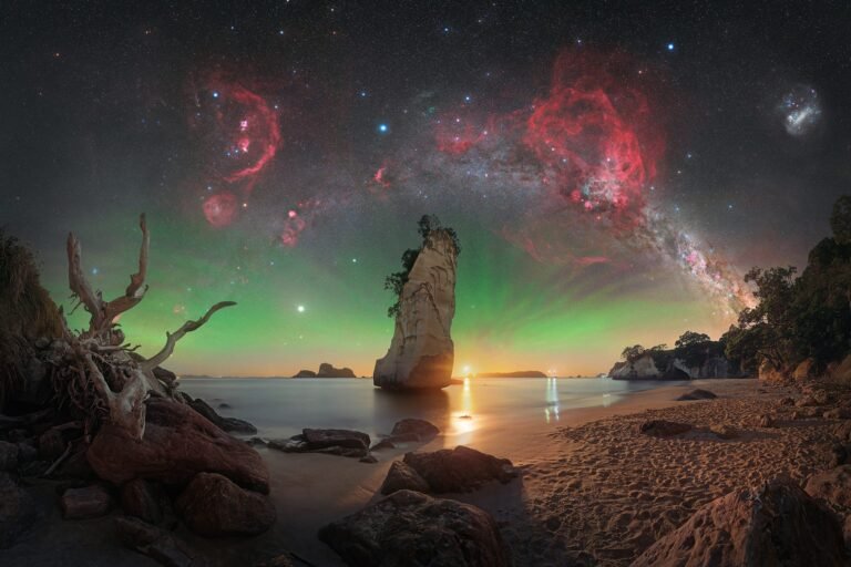 an astronomy photo of nebula over rock formations in New Zealand