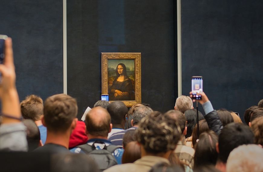Tourists capturing the iconic Mona Lisa painting at the Louvre Museum.