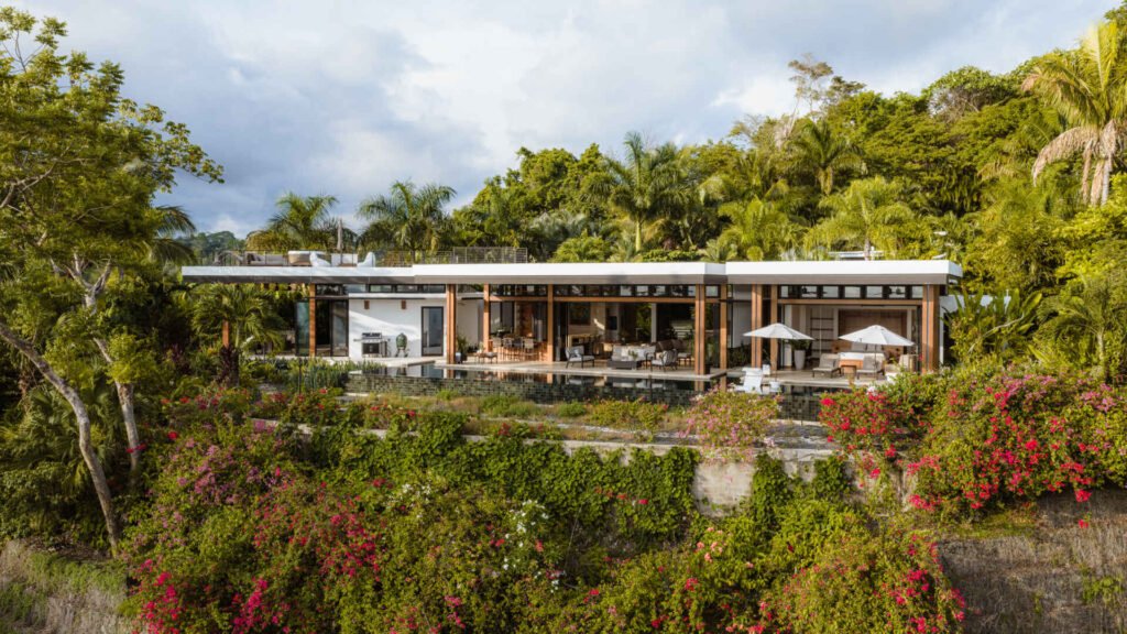 Tierra y Mar House in Mal País, Costa Rica, by Álvarez Arquitectos features layered architectural platforms, a wave-inspired roof and an exterior bridge extending toward the forest canopy.